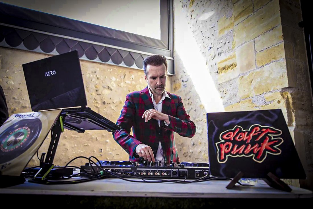 Greg Le Fourn en train de mixer derrière ses platines, vinyles en avant-plan