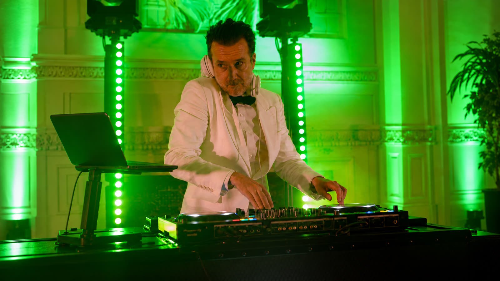 Greg Le Fourn aux platines pendant une soirée de mariage, sous des lumières vertes