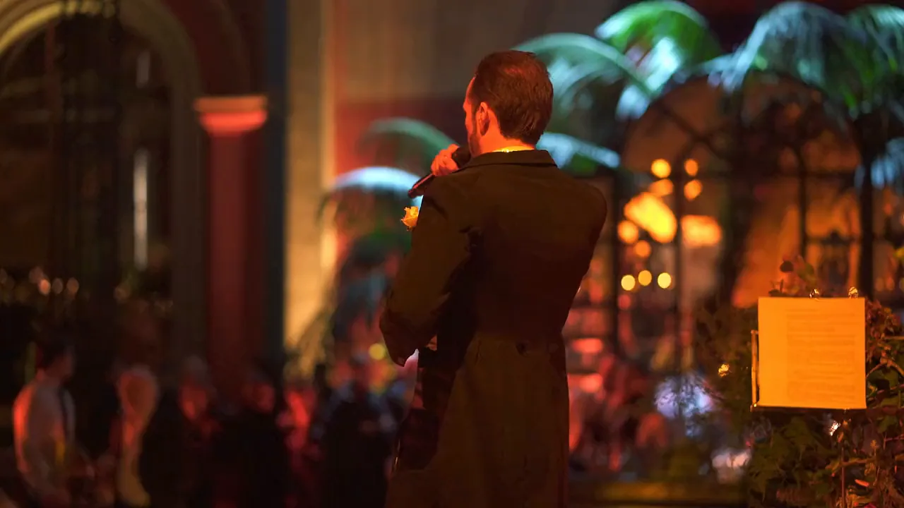 Greg Le Fourn, microphone in hand, facing the wedding guests
